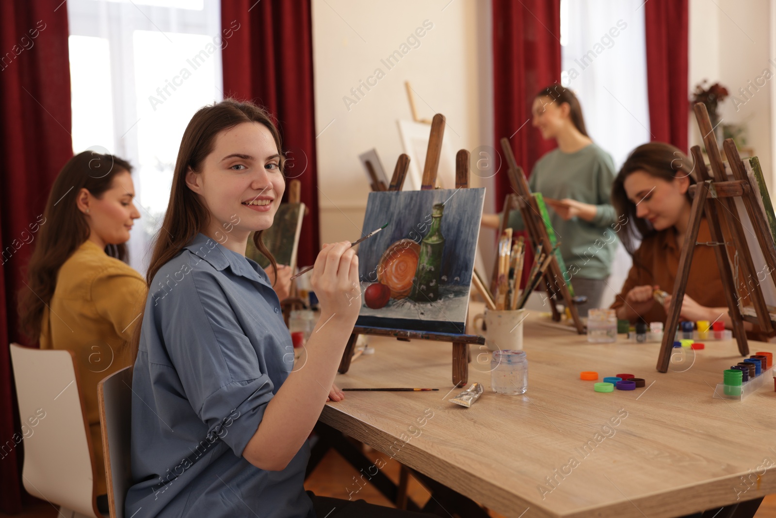 Photo of Group of women learning to draw at wooden table in class