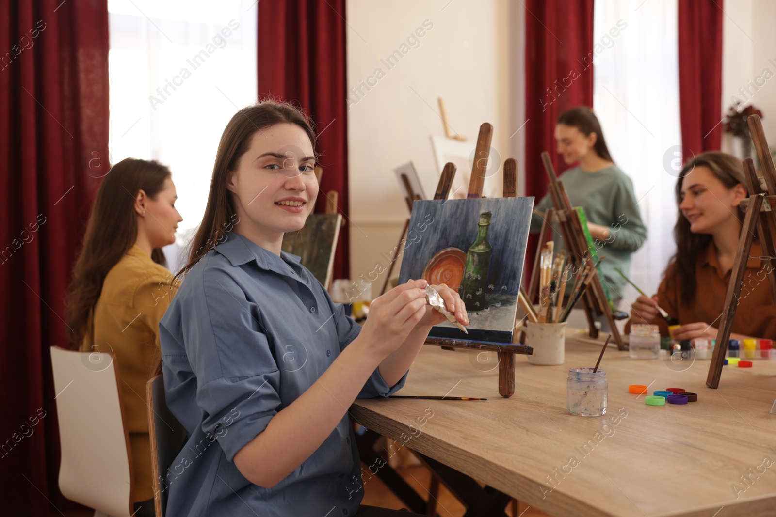 Photo of Group of women learning to draw at wooden table in class