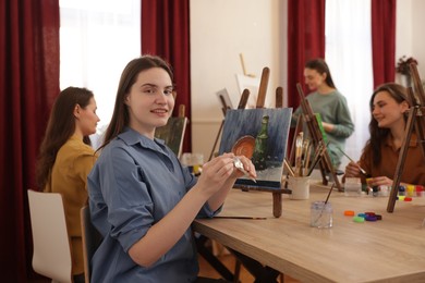 Photo of Group of women learning to draw at wooden table in class