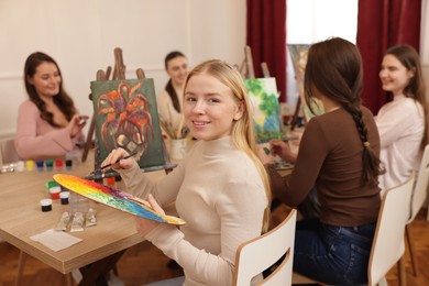 Photo of Group of women learning to draw at wooden table in class