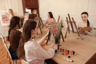 Photo of Group of women learning to draw at wooden table in class