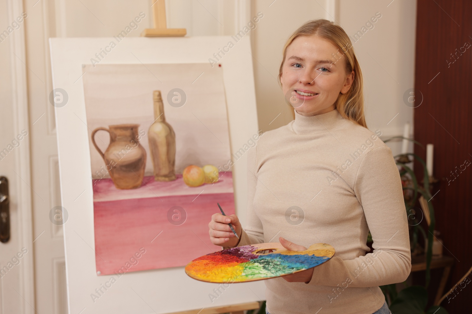 Photo of Smiling woman with palette and brush learning to draw in class