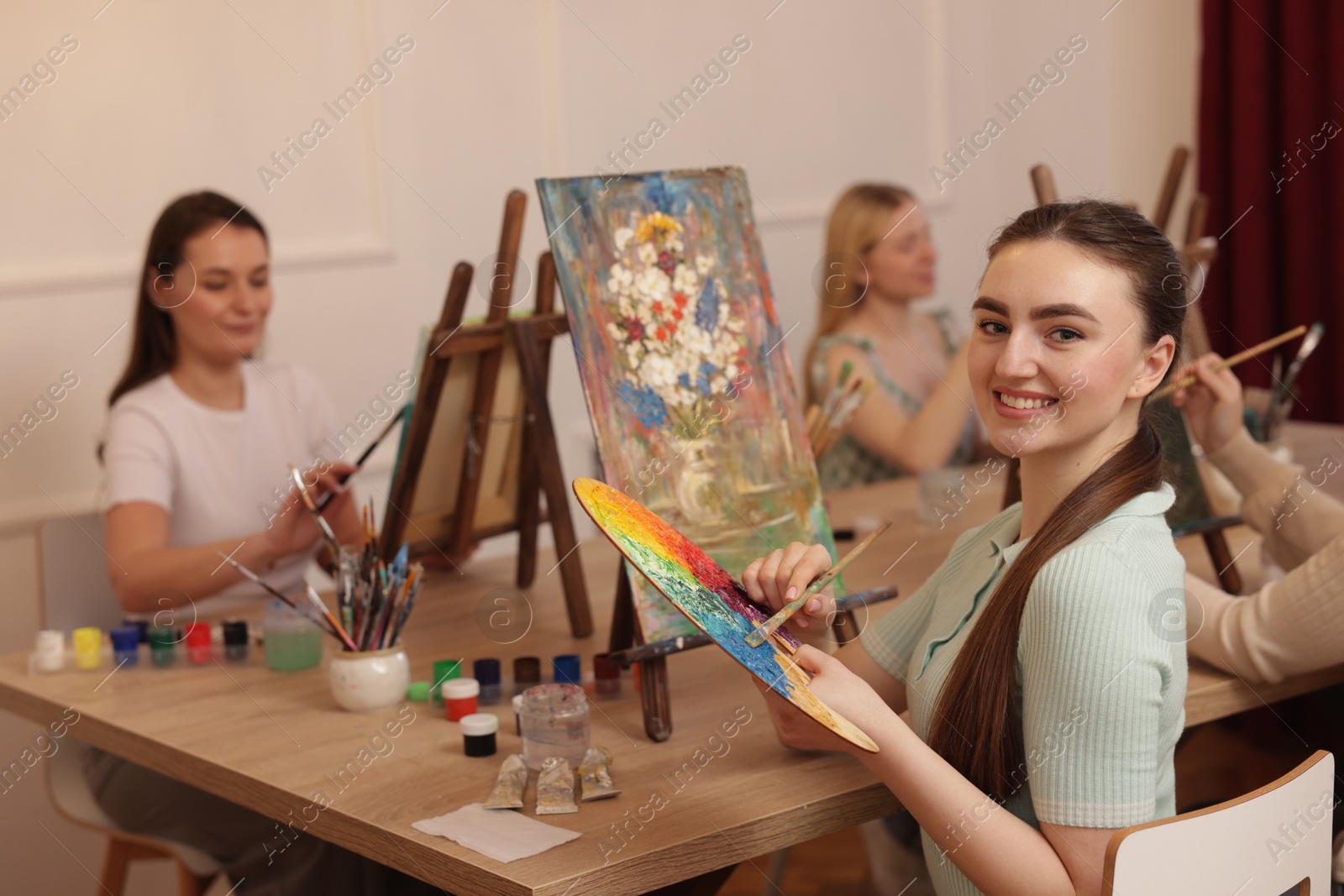 Photo of Group of women learning to draw at wooden table in class