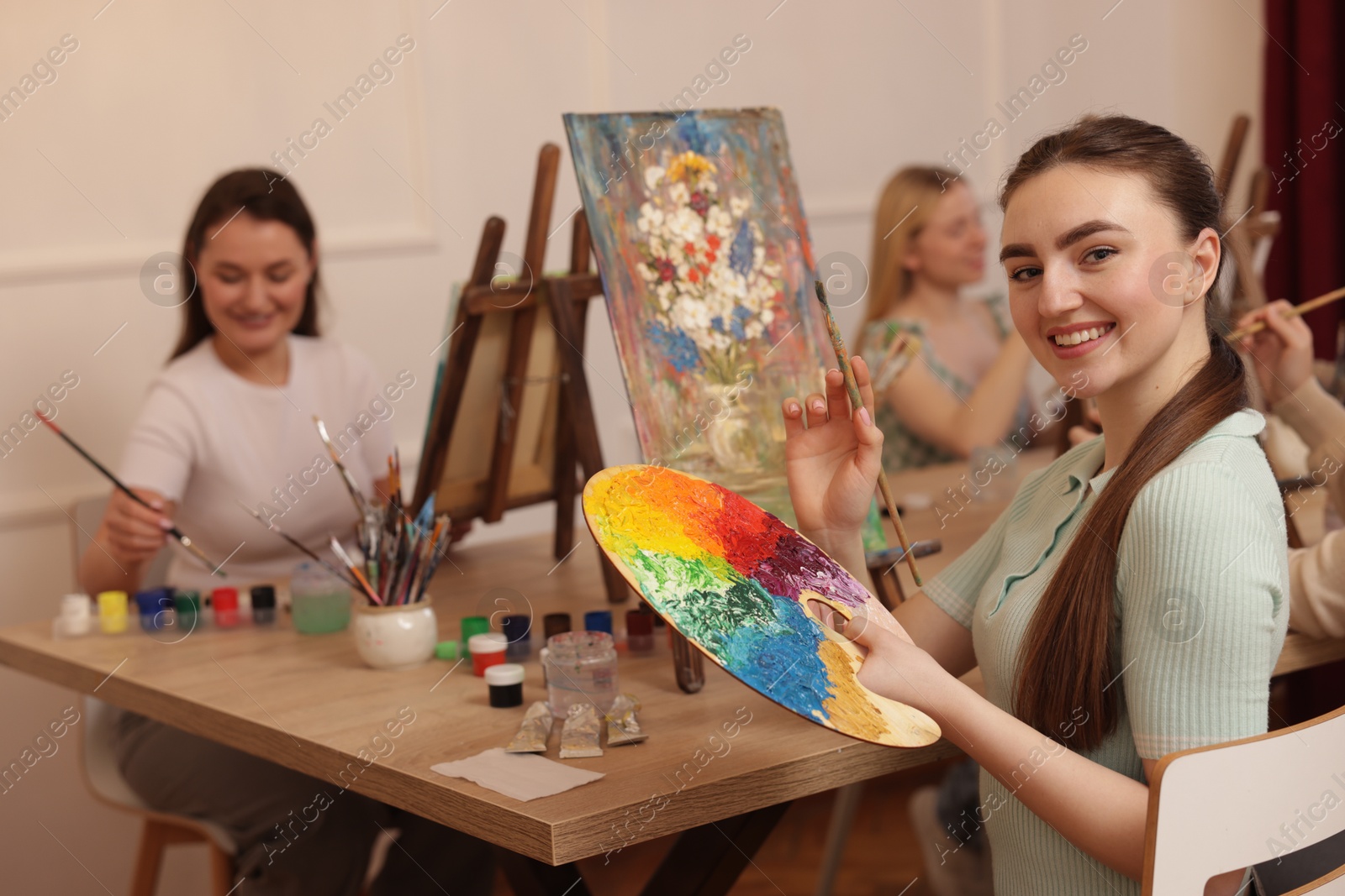 Photo of Group of women learning to draw at wooden table in class