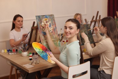 Group of women learning to draw at wooden table in class