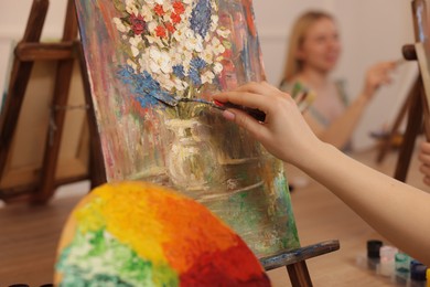 Photo of Woman with painting knife learning to draw at table in class, closeup