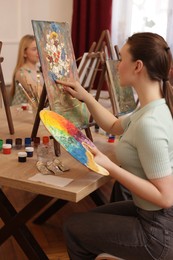 Women learning to draw at table in class, closeup