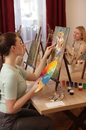 Women learning to draw at table in class, closeup