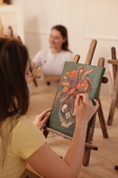 Photo of Women learning to draw at wooden table in class, closeup