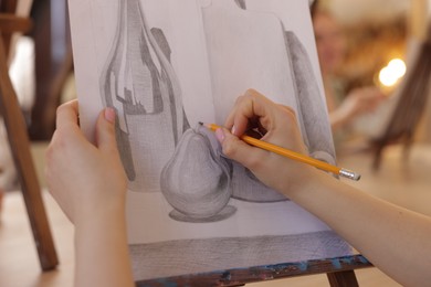 Photo of Woman with pencil learning to draw on blurred background, closeup