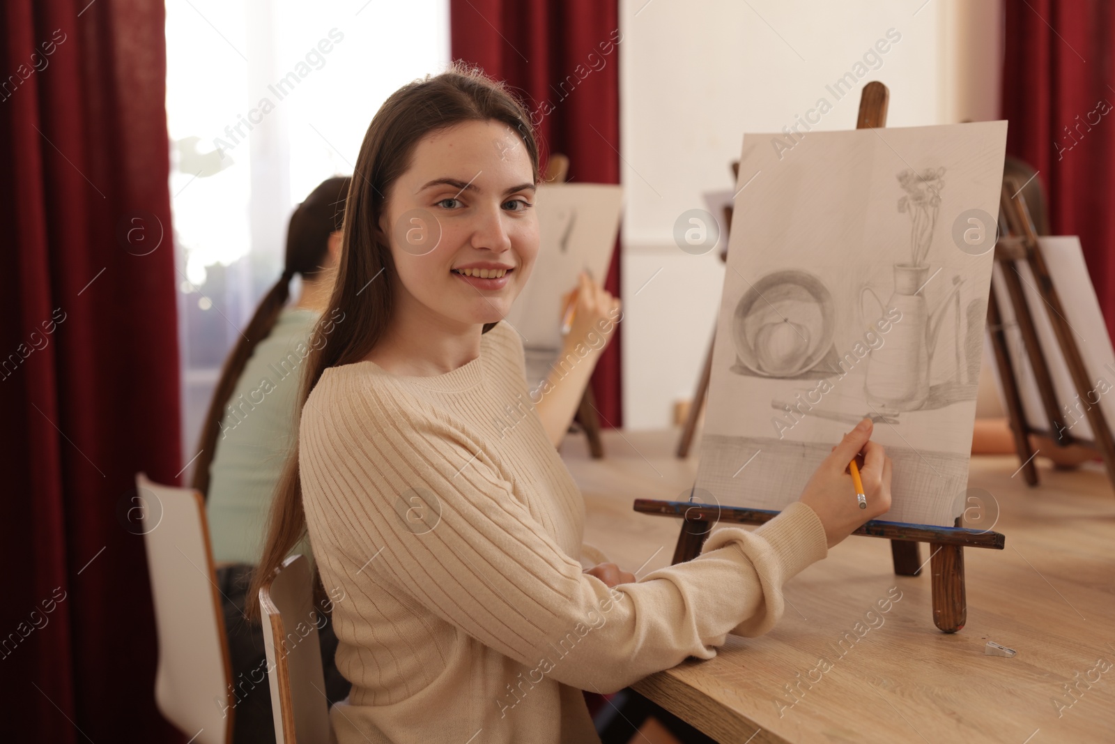 Photo of Women learning to draw at wooden table in class