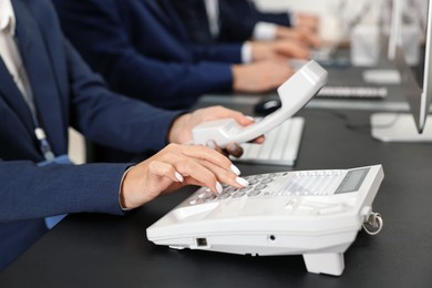 Photo of Technical support call center. Team of operators working at table in office, closeup