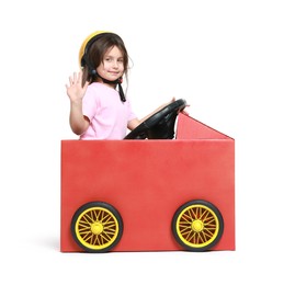 Photo of Little girl waving while driving car made with cardboard on white background