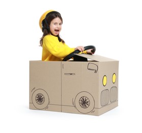 Photo of Emotional little girl driving car made with cardboard on white background