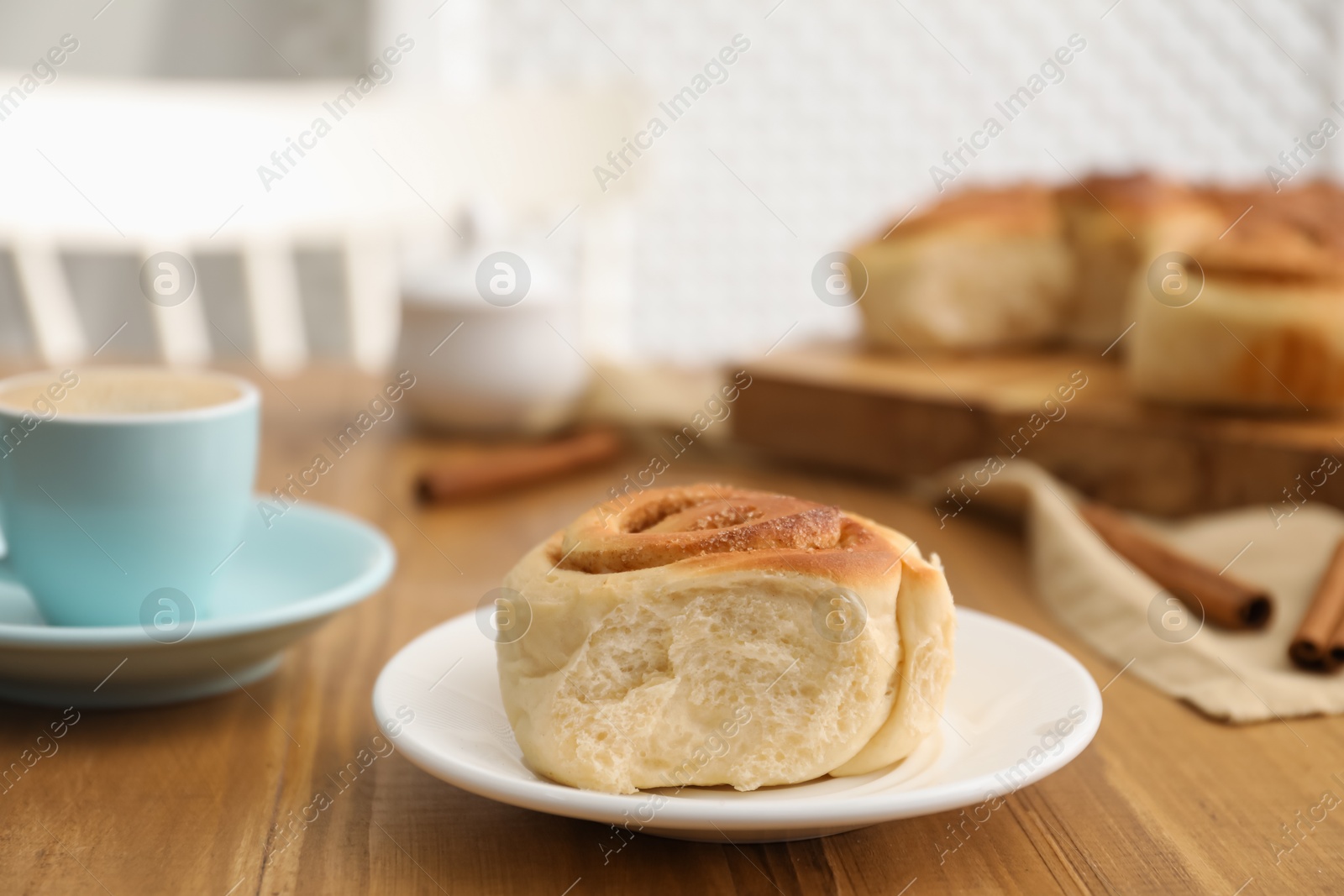 Photo of Freshly baked cinnamon roll on wooden table, closeup