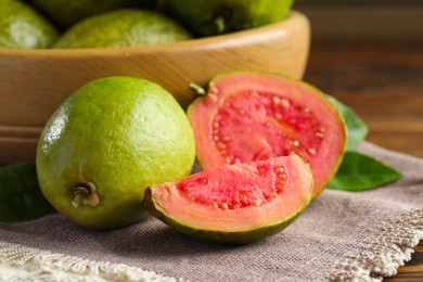 Photo of Fresh cut and whole guava fruits on table, closeup