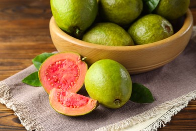 Fresh cut and whole guava fruits on wooden table