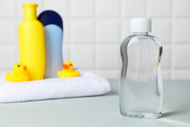 Photo of Baby oil and bath accessories on grey table, selective focus