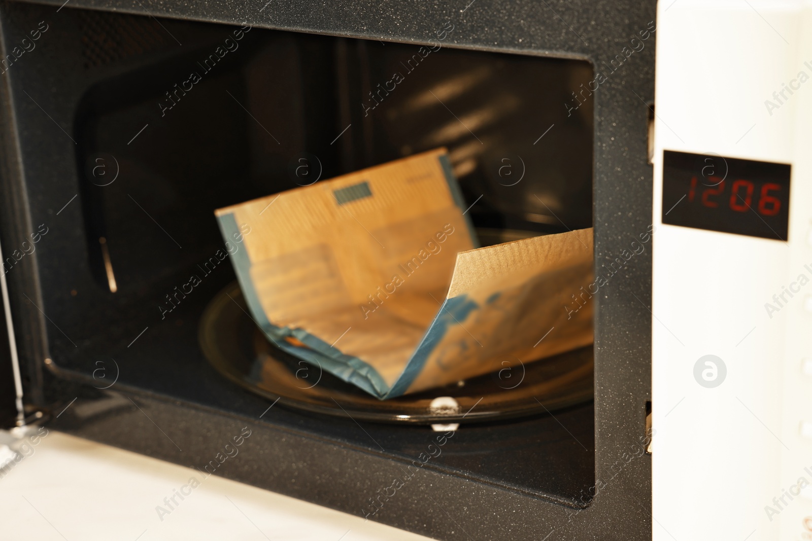 Photo of Bag of popcorn in microwave oven, closeup