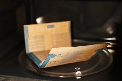 Photo of Bag of popcorn in microwave oven, closeup