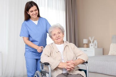 Photo of Healthcare worker with elderly woman in wheelchair indoors