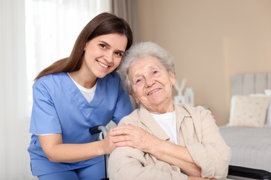 Photo of Healthcare worker with elderly woman in wheelchair indoors