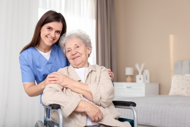 Photo of Healthcare worker with elderly woman in wheelchair indoors