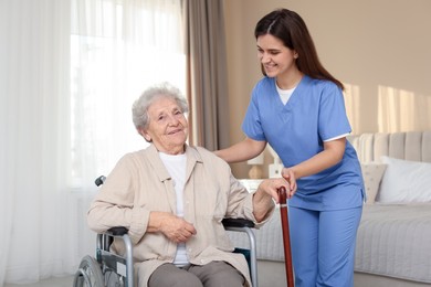 Photo of Healthcare worker with elderly woman in wheelchair indoors