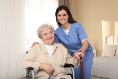 Photo of Healthcare worker with elderly woman in wheelchair indoors