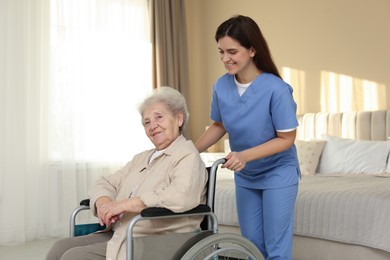 Photo of Healthcare worker with elderly woman in wheelchair indoors