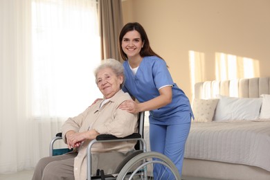 Photo of Healthcare worker with elderly woman in wheelchair indoors