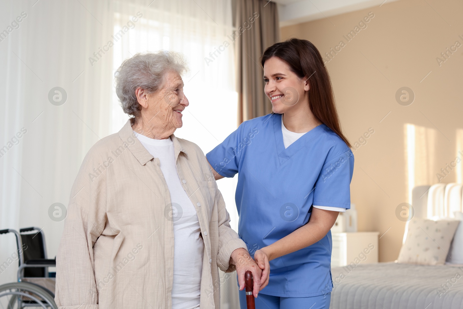 Photo of Smiling healthcare worker and elderly woman indoors