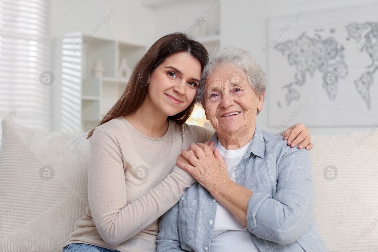 Photo of Portrait of happy granddaughter and her grandmother at home. Elderly care