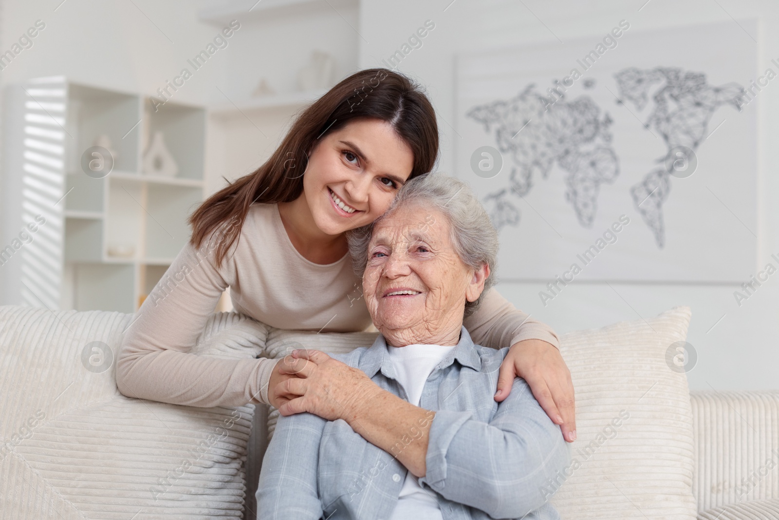 Photo of Portrait of happy granddaughter and her grandmother at home. Elderly care