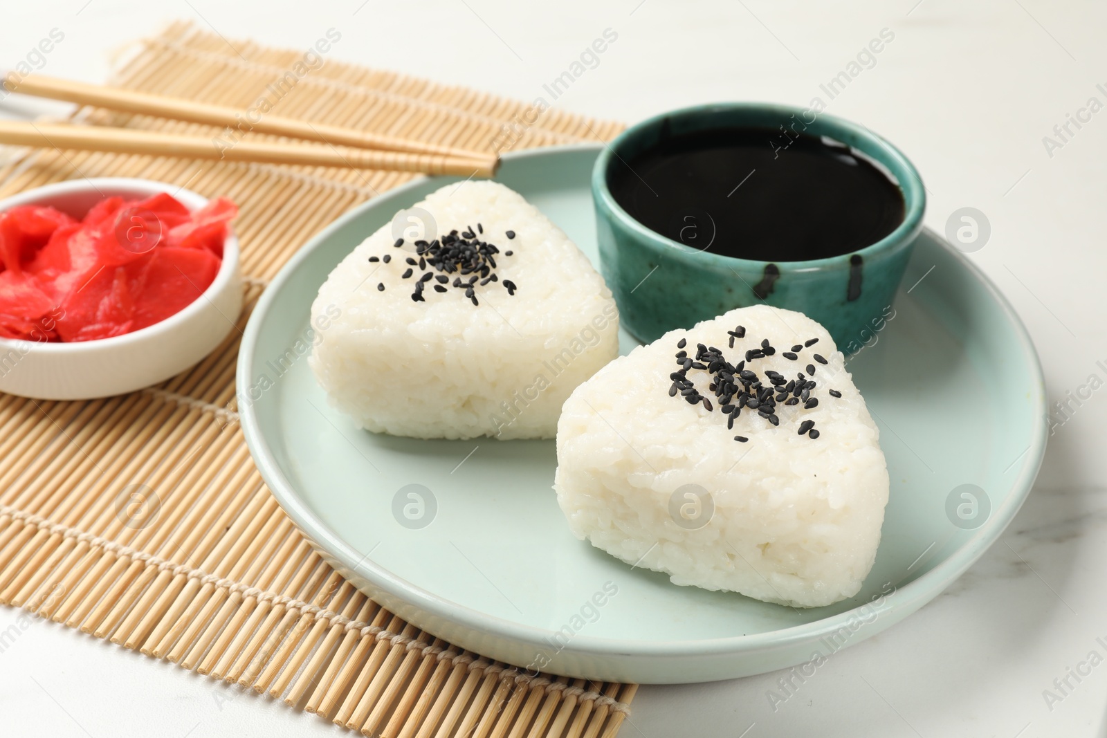 Photo of Rice balls (onigiri) served on light table, closeup. Traditional Japanese dish