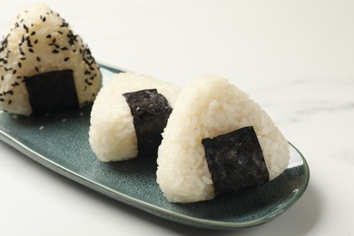 Photo of Rice balls (onigiri) on light table, closeup. Traditional Japanese dish