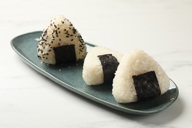 Photo of Rice balls (onigiri) on light table, closeup. Traditional Japanese dish