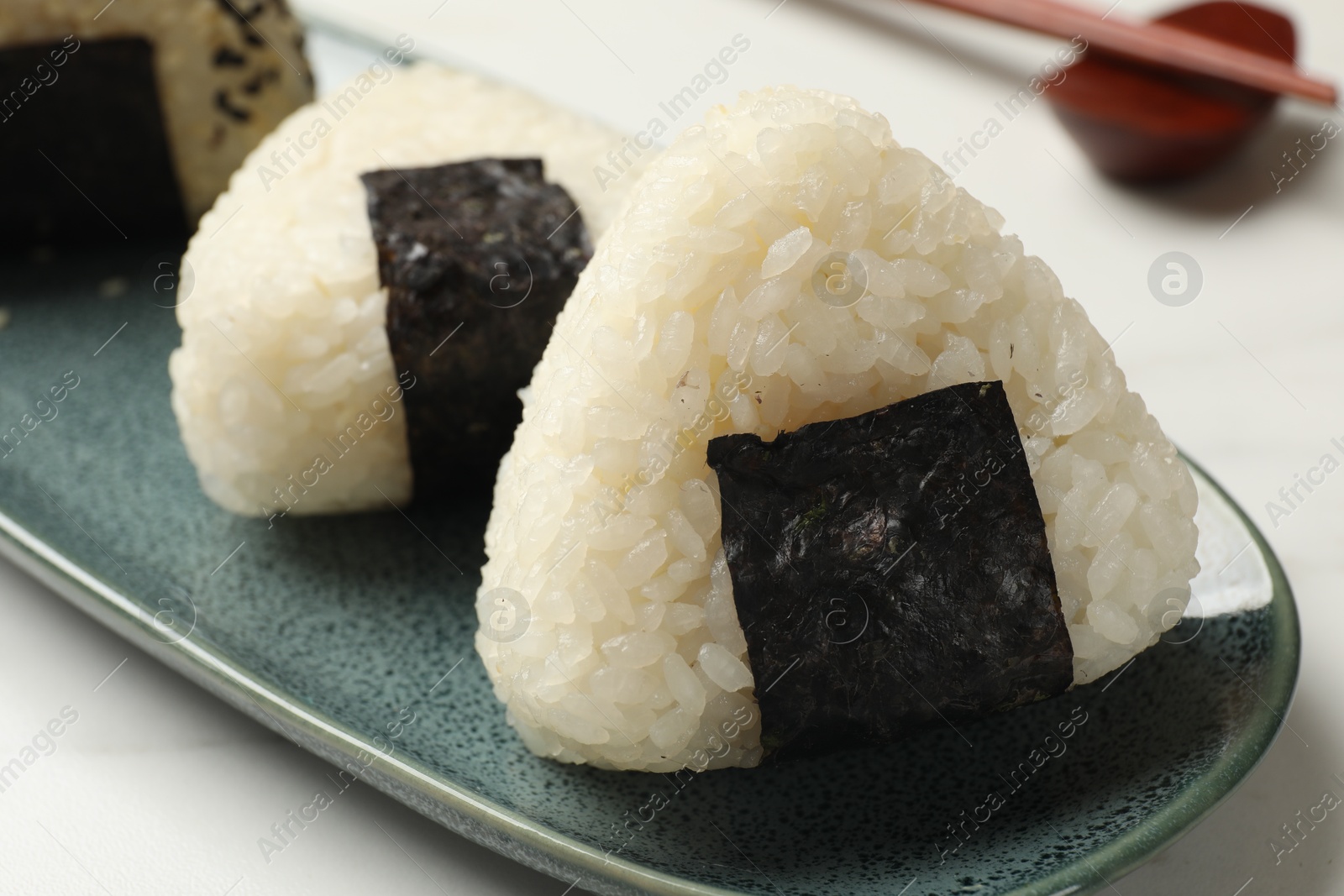 Photo of Rice balls (onigiri) on light table, closeup. Traditional Japanese dish