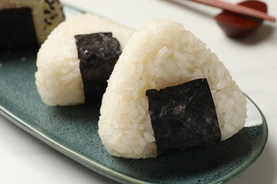 Photo of Rice balls (onigiri) on light table, closeup. Traditional Japanese dish