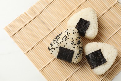 Photo of Rice balls (onigiri) on light table, flat lay and space for text. Traditional Japanese dish