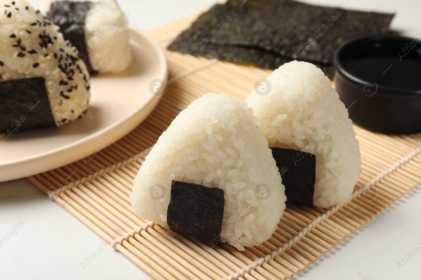 Photo of Rice balls (onigiri) on light table, closeup. Traditional Japanese dish