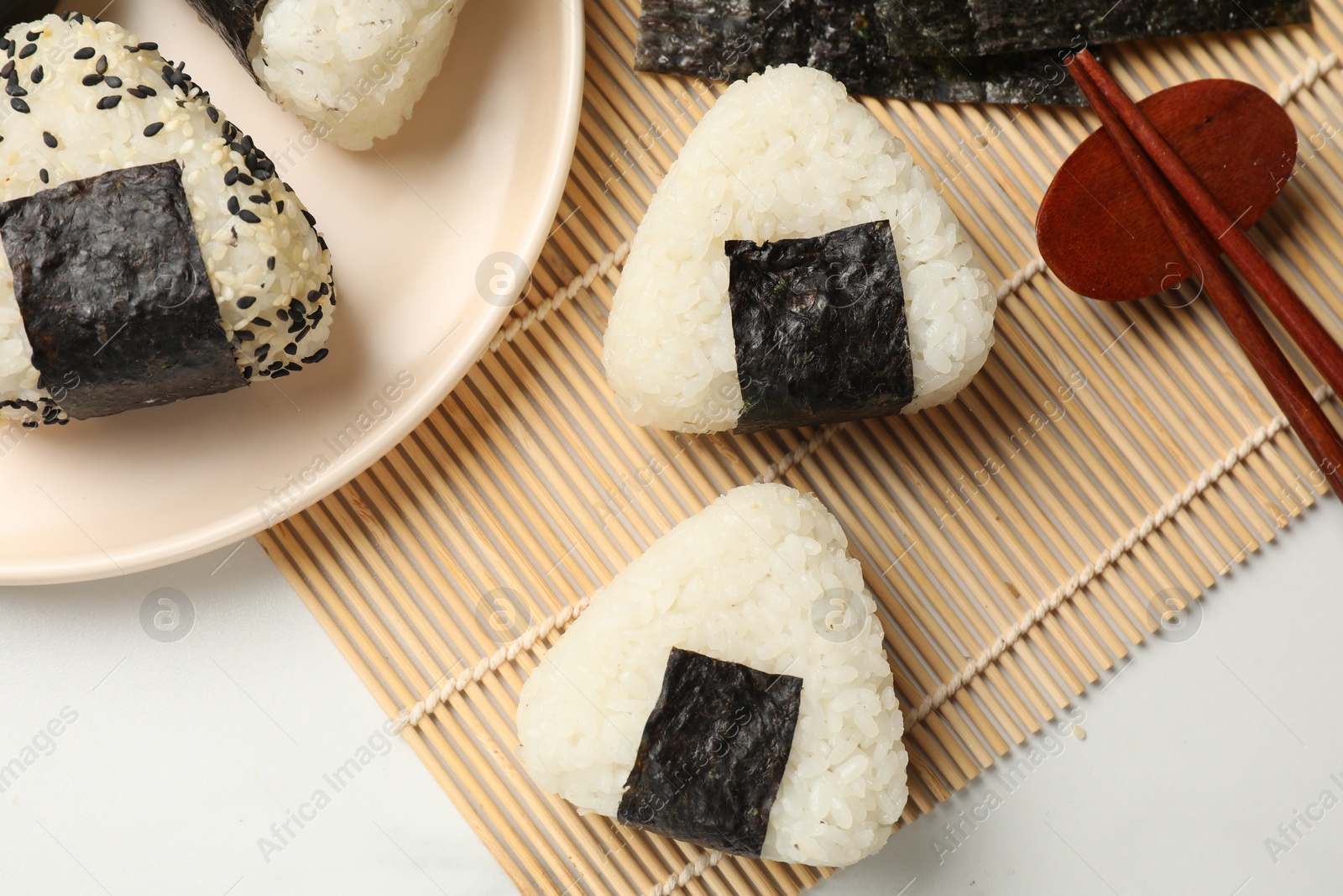 Photo of Rice balls (onigiri) served on light table, flat lay. Traditional Japanese dish