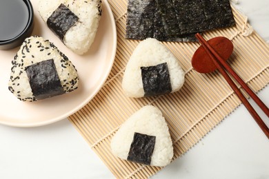 Photo of Rice balls (onigiri) served on light table, flat lay. Traditional Japanese dish