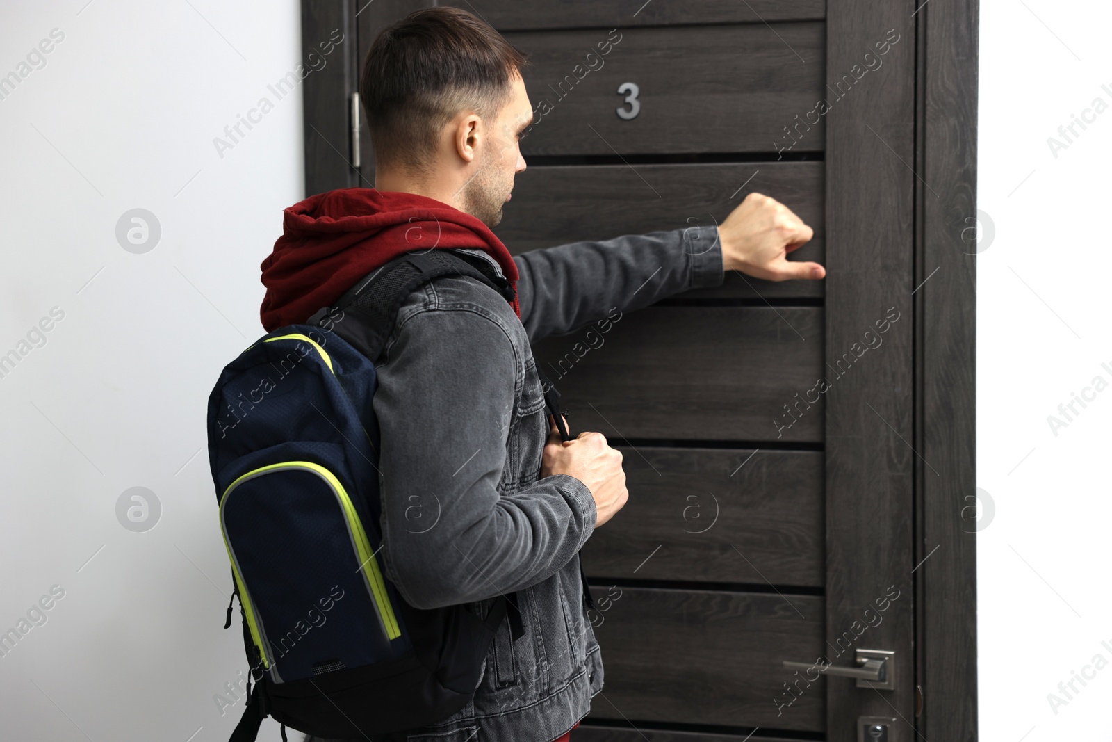 Photo of Man knocking on door of his friends apartment