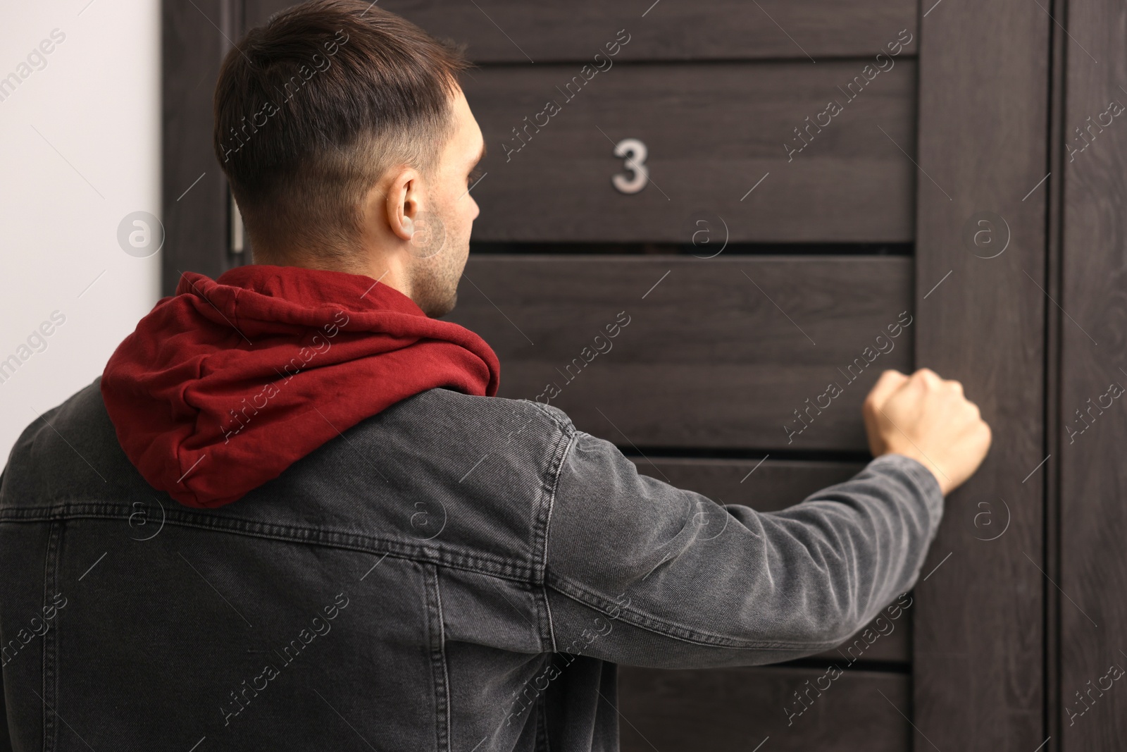 Photo of Man knocking on door of his friends apartment