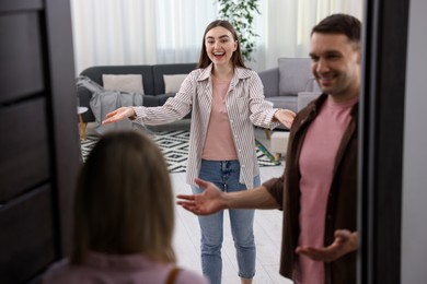 Photo of Lovely couple welcoming friend to their apartment