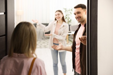 Photo of Lovely couple welcoming friend to their apartment