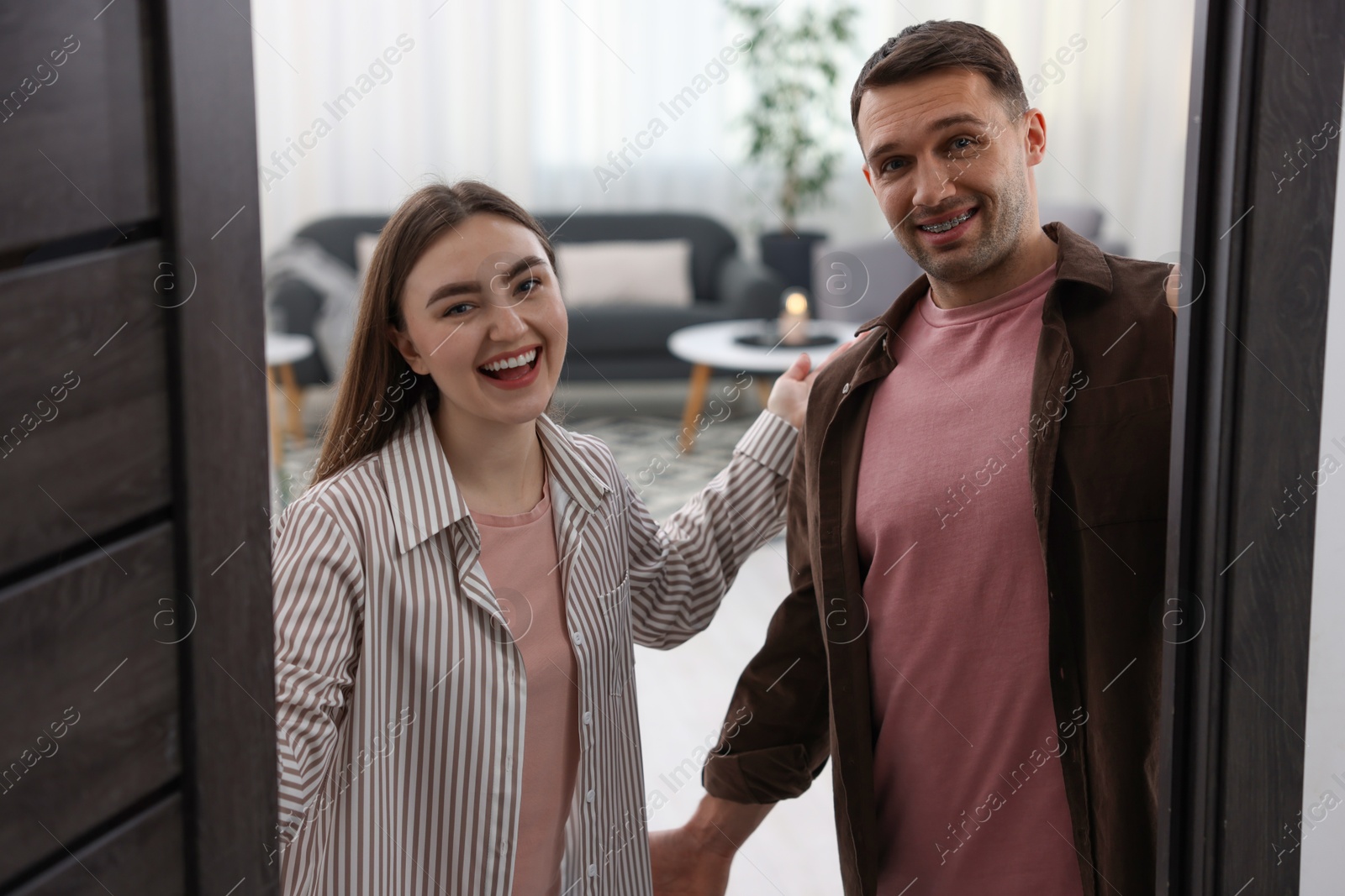 Photo of Lovely couple welcoming guests to their apartment