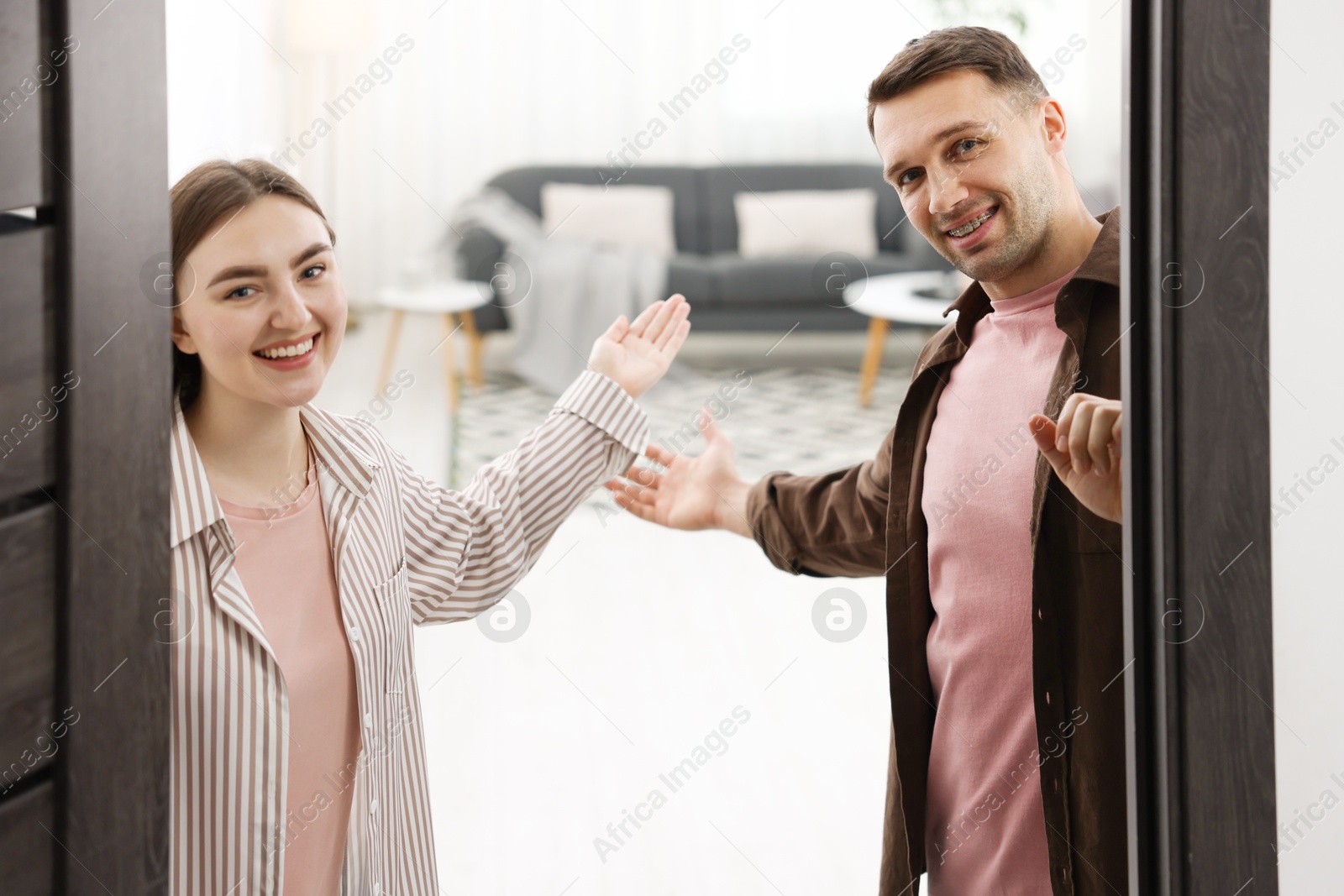 Photo of Lovely couple welcoming guests to their apartment