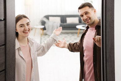 Photo of Lovely couple welcoming guests to their apartment